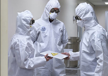 Lab workers in full HAZMAT suits assessing biological contamination