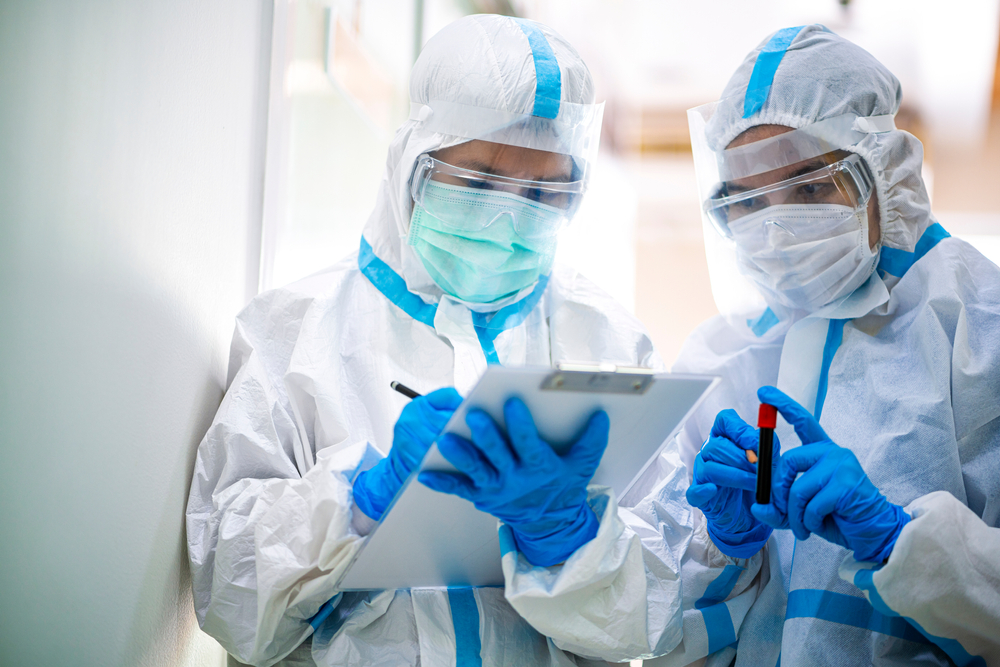 lab workers with covid-19 blooding tube wearing ppe suit and face mask in hospital