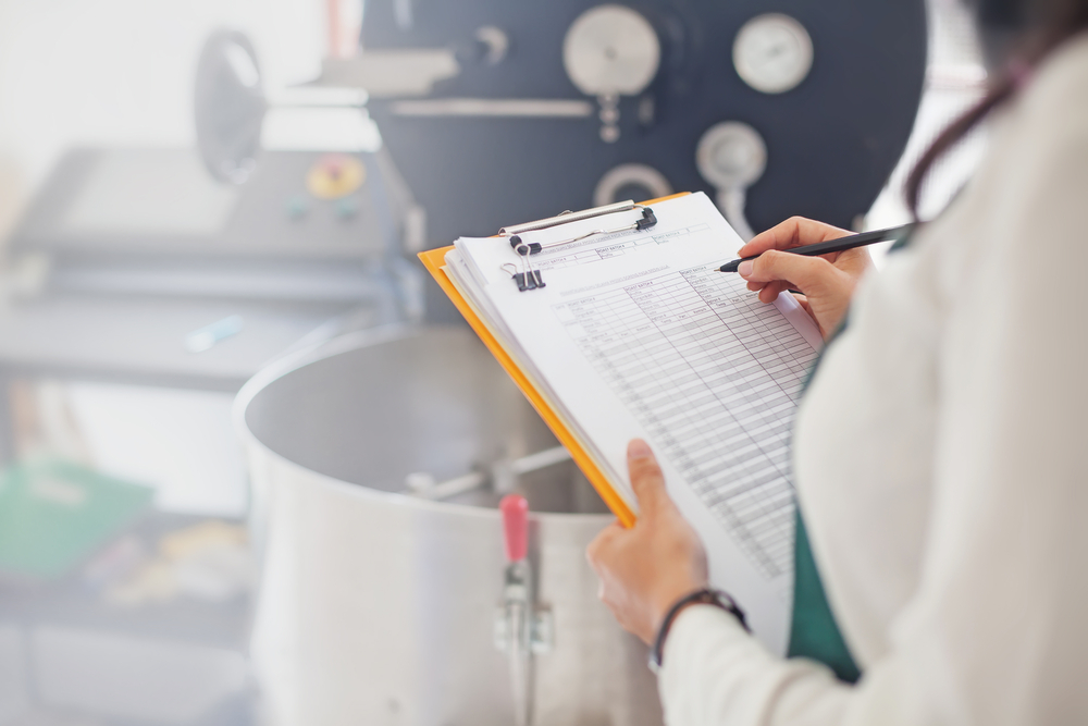 Worker using checklist for food lab safety