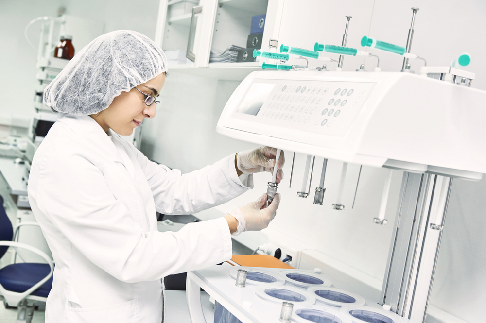 Pharmaceutical scientific female researcher in protective uniform working with dissolution tester at pharmacy industry manufacture factory laboratory