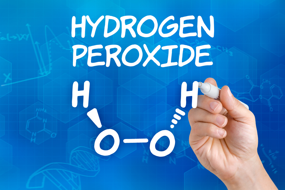 Hand with pen drawing the chemical formula of hydrogen peroxide